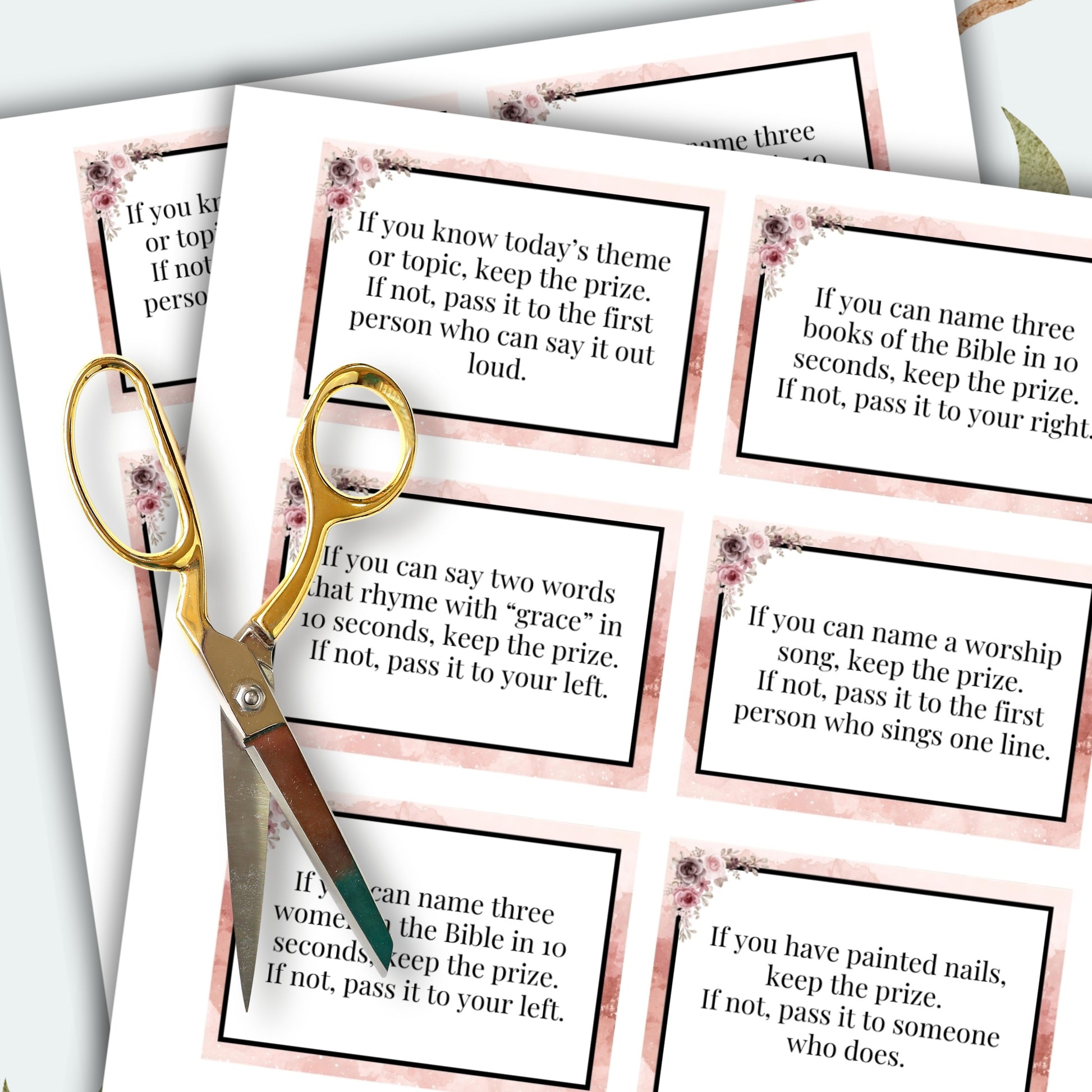Game cards with questions and a pair of scissors on a white background